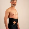 Man wearing a black ostomy hernia support belt with a pouch opening